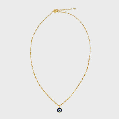 Gold necklace with a small evil eye pendant on a light gray background